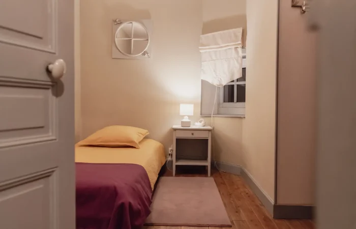 Chambre single du gîte Le Presbytère au Parc de Lesseps — lit une personne, linge moutarde et prune, parquet pin, chambre individuelle pour hébergement groupe mariage ou séjour famille en Berry Indre