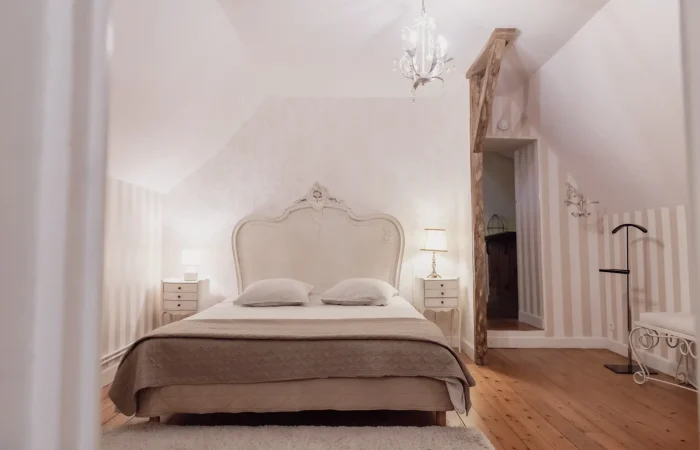 Suite Diane du gîte Le Presbytère — lit baroque sculpté, papier peint à rayures beige, parquet pin, chambre double romantique pour séjour ou mariage en Indre