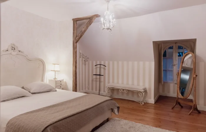 Suite Diane — miroir psyché en bois naturel, fenêtre en arche, banquette en fer forgé, ambiance romantique et lumineuse pour séjour de charme au Parc de Lesseps